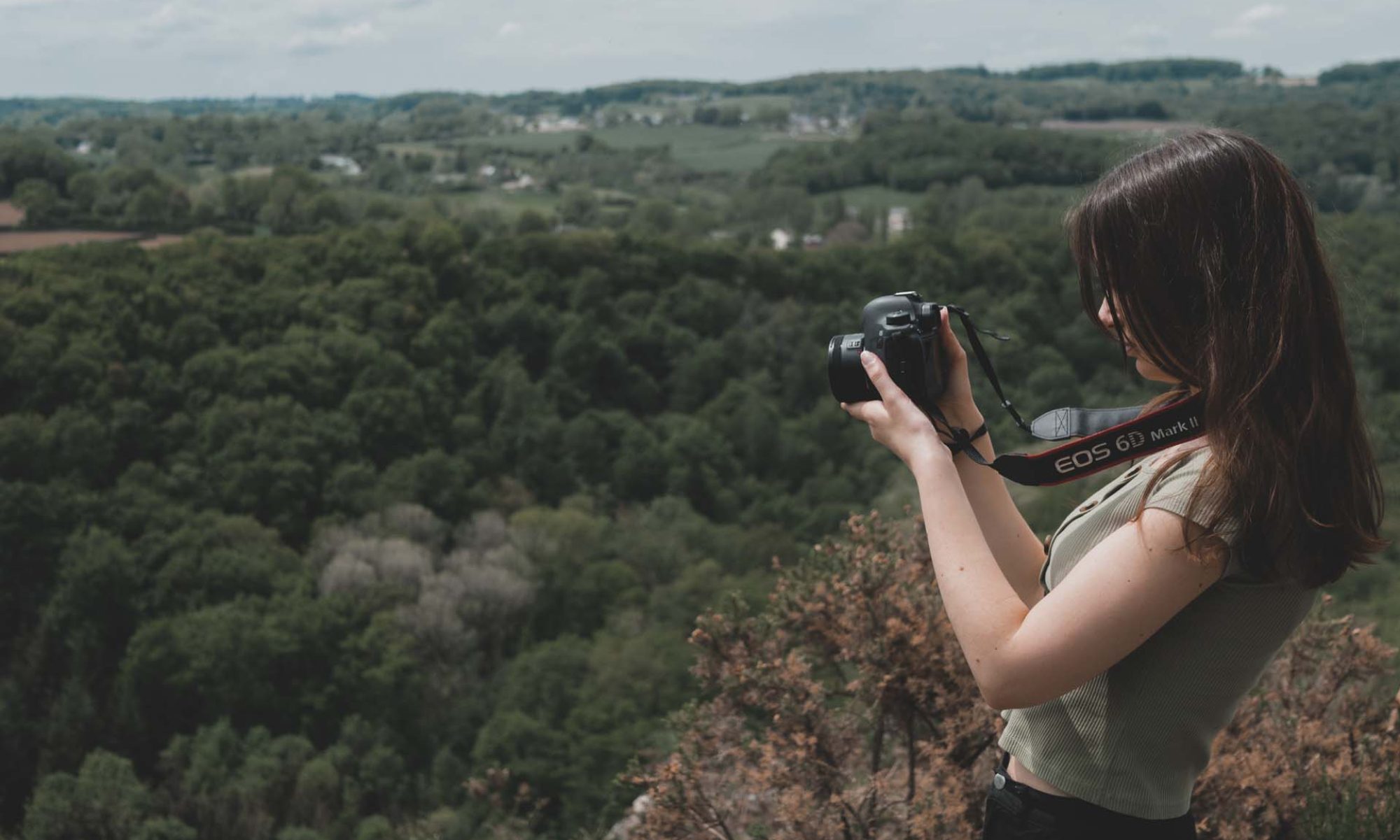 photo Mallaurie Photographe avec son appareil photo devant un paysage de nature